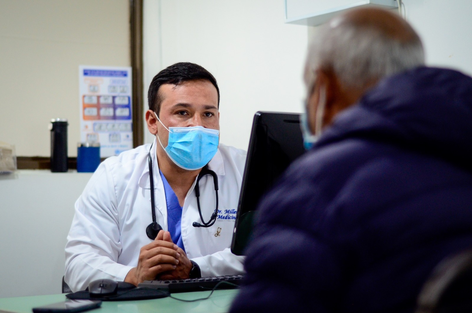 A doctor has a consultation with a patient. The patient's face is not seen.