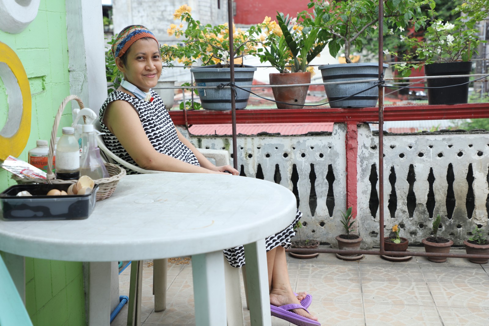 Ms. Jho-Ann Pulgo sits outside her home